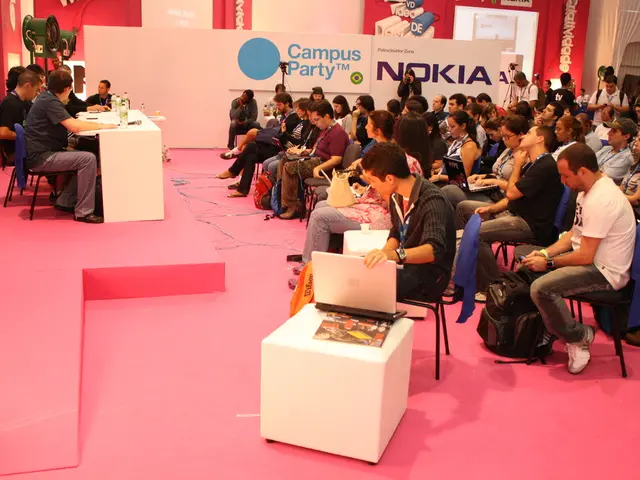 In this image there is a conference in which there are people sitting in chair and listening to the...